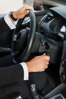 Man starting a car. Close-up of man in formalwear starting a car photo