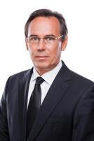 Confident business expert. Portrait of confident mature man in formalwear and eyeglasses looking at camera while standing against white background photo