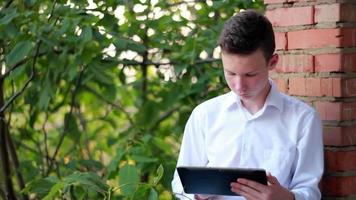junger männlicher Student mit Tablet-Computer im Park video