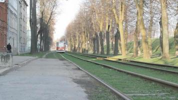 tramway rouge et blanc s'arrêtant pour décharger un passager, exploité par le système de tramway daugavpils, situé à daugavpils, en lettonie. video