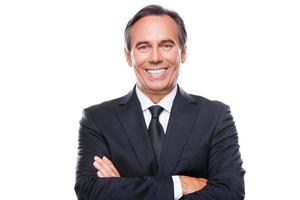 Used to success. Portrait of confident mature man in formalwear looking at camera and smiling while keeping arms crossed and standing against white background photo