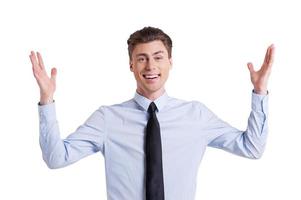 I am happy Happy young man in shirt and tie looking at camera and gesturing while standing isolated on white photo