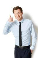 llámame joven apuesto con camisa y corbata gesticulando y sonriendo mientras está aislado en blanco foto