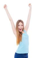 Young winner Happy teenage girl keeping arms raised while standing isolated on white photo