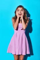 No way Surprised young woman making a face and looking at camera while standing against blue background photo