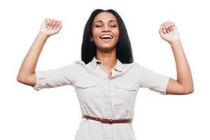 Young and successful. Happy young African woman keeping arms raised and eyes closed while standing against white background photo