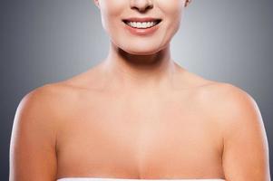 Natural beauty. Portrait of shirtless mature woman smiling while standing against grey background photo