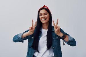 Attractive young woman in bandana looking at camera and gesturing photo