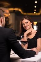 Romantic date at the restaurant. Beautiful young couple talking to each other and smiling while spending time at the restaurant photo