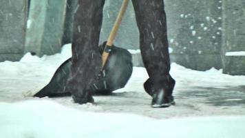 hombre cepillando pala de nieve en una calle de la ciudad video