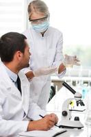 This is what we are testing today. Side view of two scientists making experiments while sitting in the laboratory photo