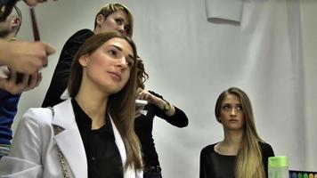 el maquillador aplica maquillaje a la modelo facial para el desfile de moda video