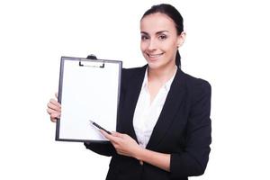 Woman pointing copy space. Businesswoman pointing at empty paper on a clipboard over white background photo