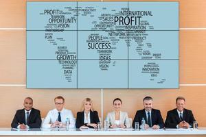 International conference. Group of business people looking at camera with smile while sitting at the tribune against world map photo