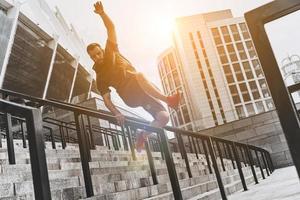 mejor cardio. toda la longitud de un joven con ropa deportiva saltando mientras hace ejercicio al aire libre foto