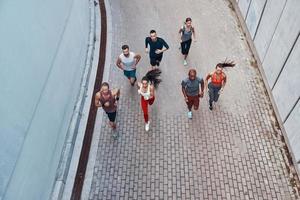 Top view of young people in sports clothing jogging while exercising outdoors photo