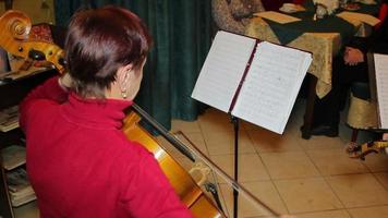 mulher tocando música de violoncelo no quarto video