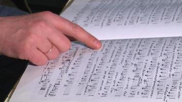 close up of a human hand turning page music book video