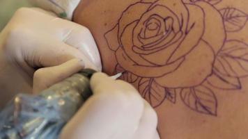 el maestro de la aguja del tatuaje dibuja un patrón en la espalda video