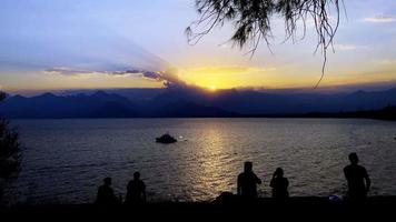 silueta de personas cerca del mar a la luz del atardecer video