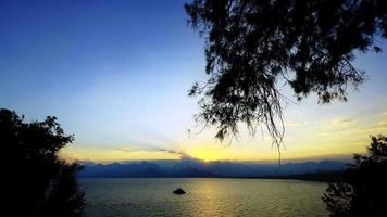 silhouette de personnes près de la mer à la lumière du coucher du soleil video