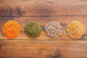 Different groats. Top view of different kinds of groats laying on the wooden desk photo
