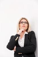 Waiting for inspiration. Low angle view of confident mature businesswoman holding hand on chin and looking away photo