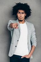 I choose you Young African man pointing on you and looking at camera while standing against grey background photo