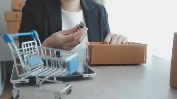 joven mujer de negocios asiática que usa una llamada de teléfono móvil que recibe una orden de compra y verifica el producto en stock, trabaja en la oficina de su casa. Entrega de mercado en línea para pequeñas y medianas empresas, concepto independiente de estilo de vida. video