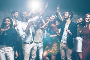 Cool party. Group of beautiful young people dancing together and looking happy photo