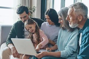 Carefree family spending time together and smiling while sitting on the sofa at home photo