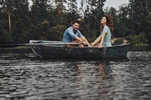 felices de tenernos el uno al otro. hermosa pareja joven disfrutando de una cita romántica y sonriendo mientras rema un bote