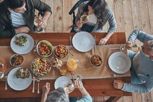 Top view of multi-generation family communicating while having dinner together photo