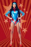 She can fight crime anywhere. Full length of beautiful young woman in superhero costume looking at camera and keeping hands on hips while standing against red background photo