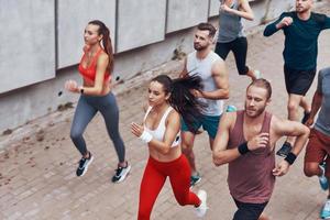 Top view of young people in sports clothing jogging while exercising outdoors photo