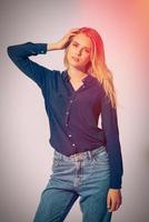 Young and beautiful. Studio shot of beautiful young woman wearing black shirt holding hand in hair and looking at camera photo