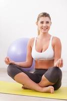 Finding harmony inside. Beautiful mature woman mediating while sitting in lotus position photo