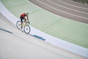 Top view of man in sports clothing cycling on track outdoors photo