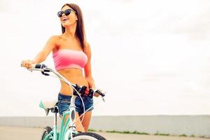 What a great day Beautiful young woman standing near her bicycle and smiling photo