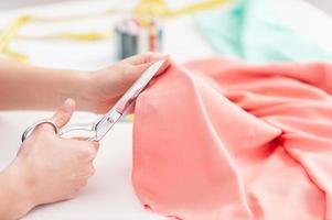 Tailor at work. Cropped image of tailor cutting cloth photo