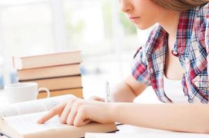 preparándose para sus exámenes finales. imagen recortada de una adolescente estudiando sentada en el escritorio foto