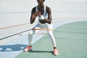 primer plano de una joven africana confiada en ropa deportiva haciendo ejercicio al aire libre foto