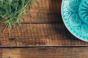 Modern and fresh. Top view of pattern plate lying on wooden rustic table with grass photo