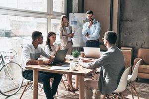 trabajar algunos conceptos. dos jóvenes colegas que realizan una presentación de negocios mientras trabajan en la oficina creativa foto