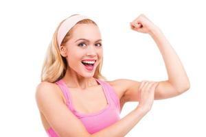 I got perfect biceps Beautiful pin-up blond hair woman in pink shirt touching her bicep and smiling while standing isolated on white background photo