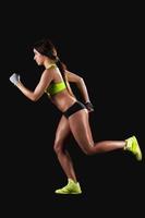 Woman jogging. Jogging female athlete on black background photo