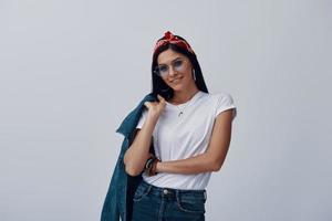 mujer joven atractiva en bandana mirando a la cámara y sonriendo foto