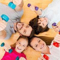 Living an active life. Top view of happy sporty family bonding to each other while lying on the floor and holding dumbbells photo
