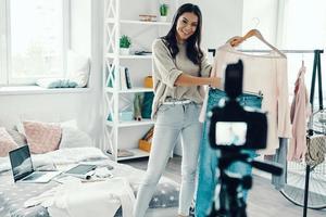 Beautiful young woman in casual clothing making social media video while spending time at home photo