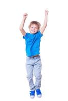 Happy little boy. Happy little boy keeping arms raised and smiling while jumping photo
